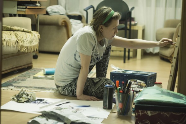 Caucasian artist on painting in living room