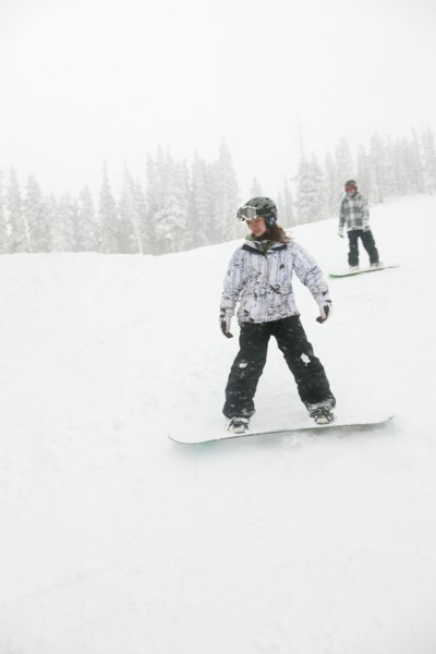 Snowboarders descending ski slope