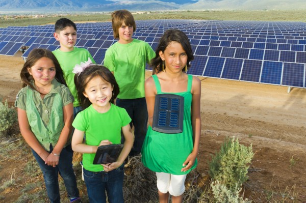 Children standing together in solar panel field