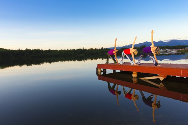 Woman exercising on lake pier