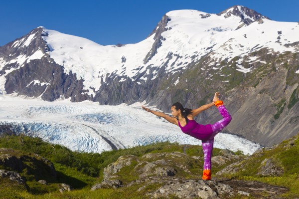 Korean woman practicing yoga with mountain in background
