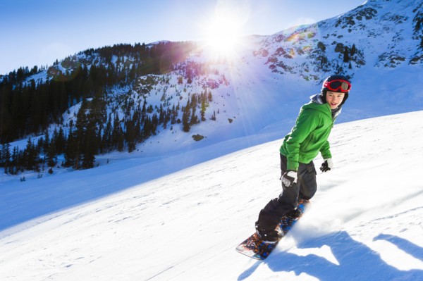 Mixed race teenager snowboarding