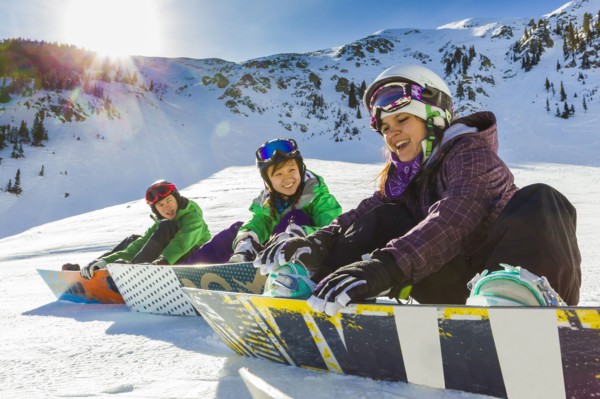 Teenagers snowboarding together
