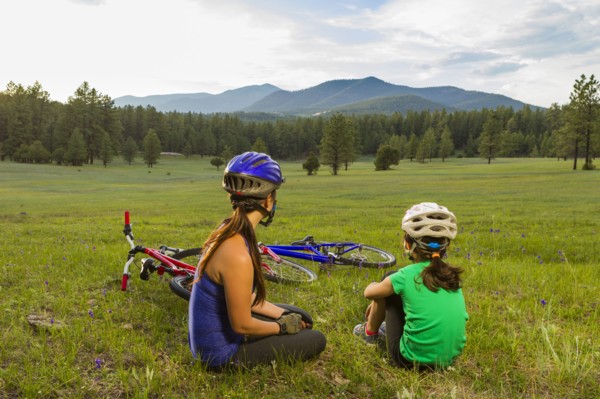 Mother and daughter sitting in meadow
