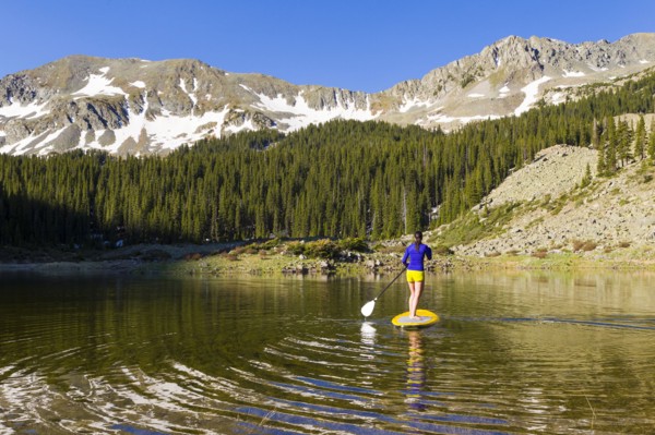 Hispanic woman riding paddle board