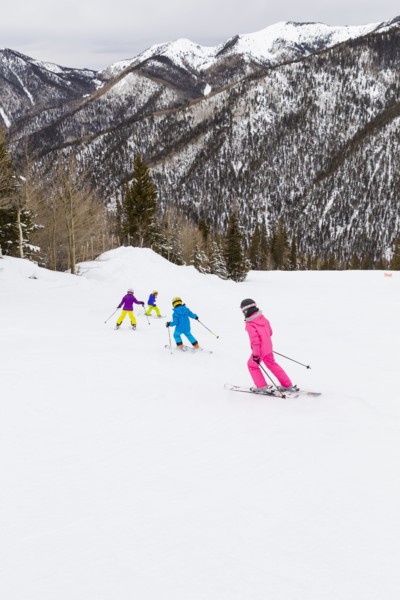 Children skiing together on snowy slope