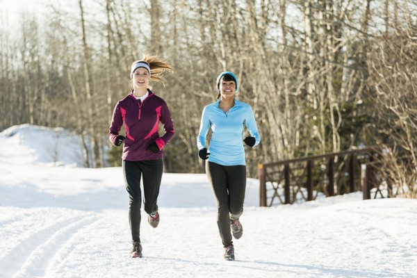 Women running on snow in winter