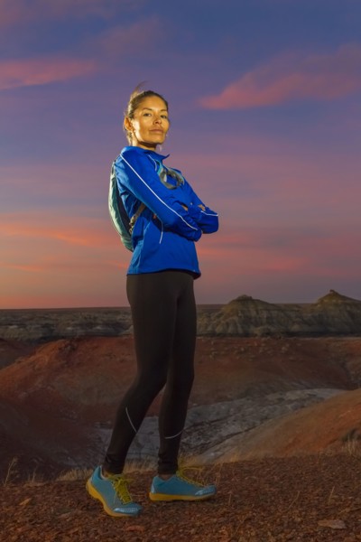Native American woman standing in desert at sunset