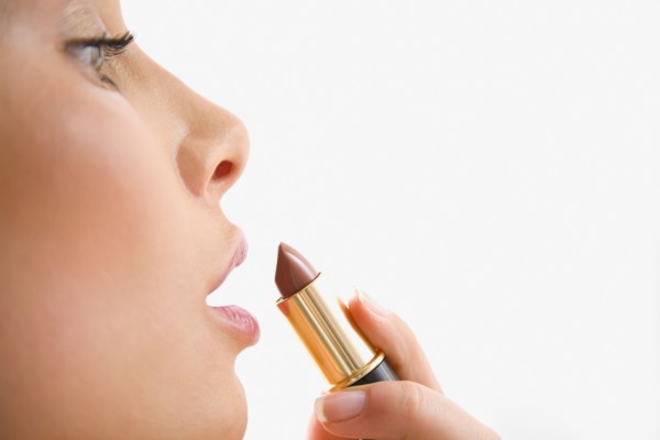 Mixed race woman applying lipstick