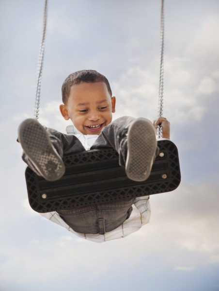 Mixed race boy swinging