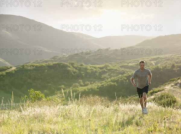 Caucasian man running on remote hill