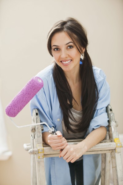 Caucasian woman holding paint roller