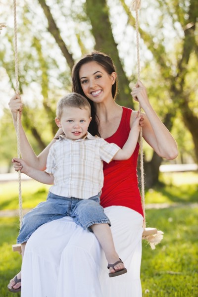 Caucasian mother and son swinging together