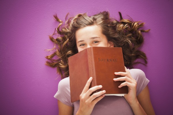 Caucasian teenager holding journal