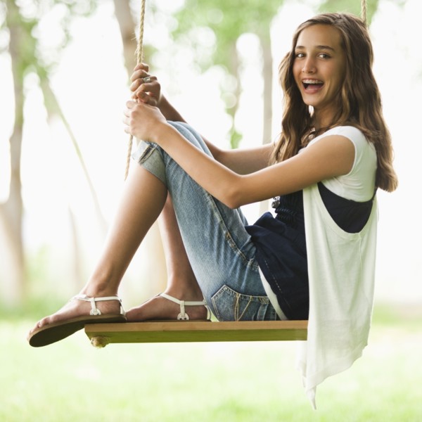 Caucasian girl sitting on swing
