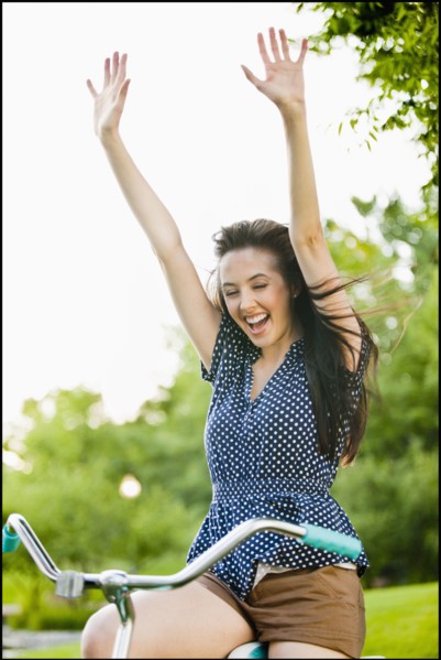 Cheering Caucasian woman cheering on bicycle