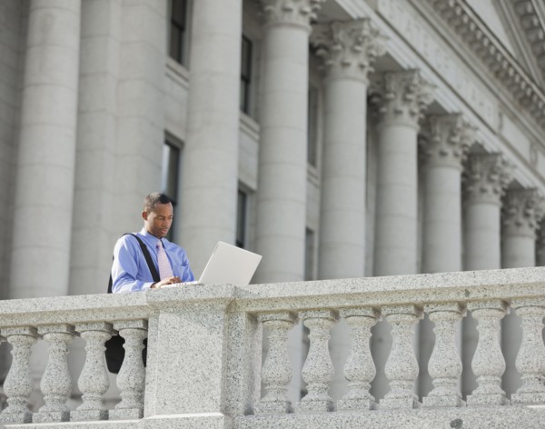 Black businessman using laptop outdoors