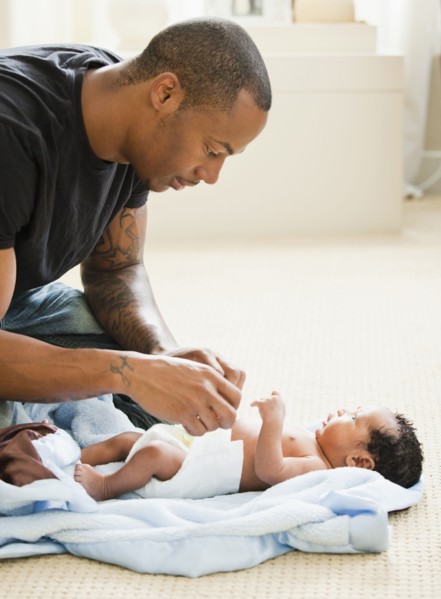 Father changing newborn baby's diaper