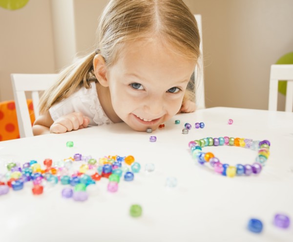 Caucasian girl stringing beads