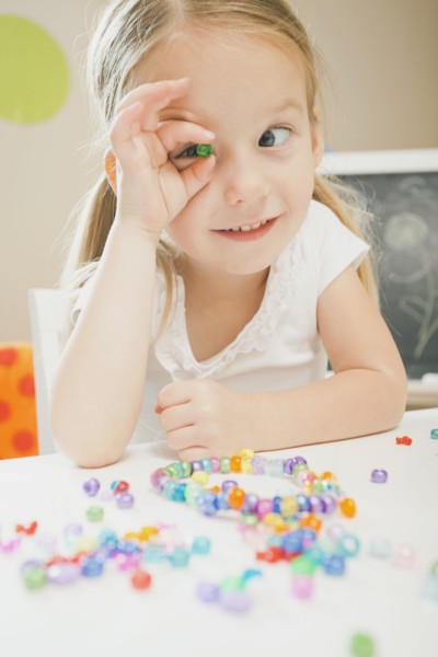 Caucasian girl playing with beads