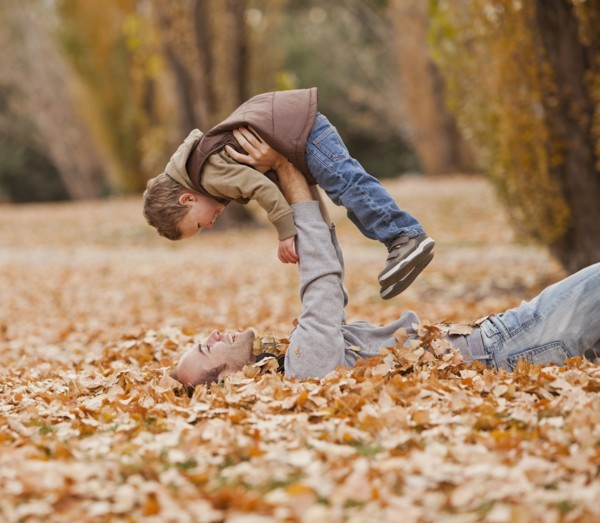Caucasian father and son playing in autumn leaves