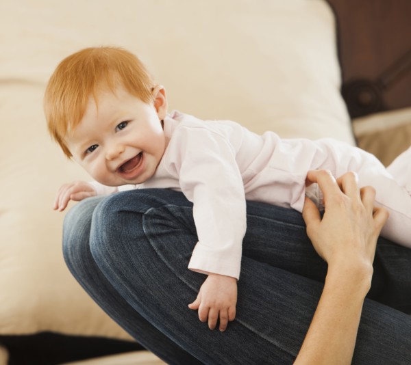 Caucasian mother playing with baby daughter