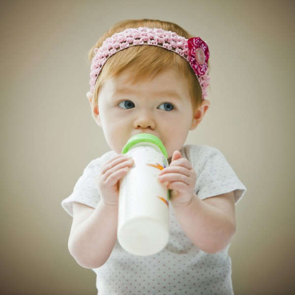 Caucasian baby girl drinking bottle