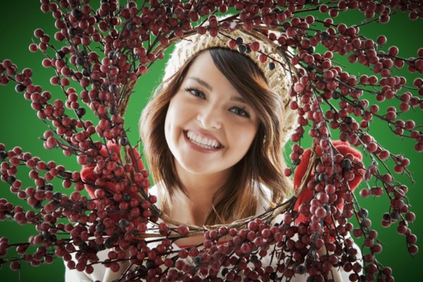 Mixed race woman holding berry wreath