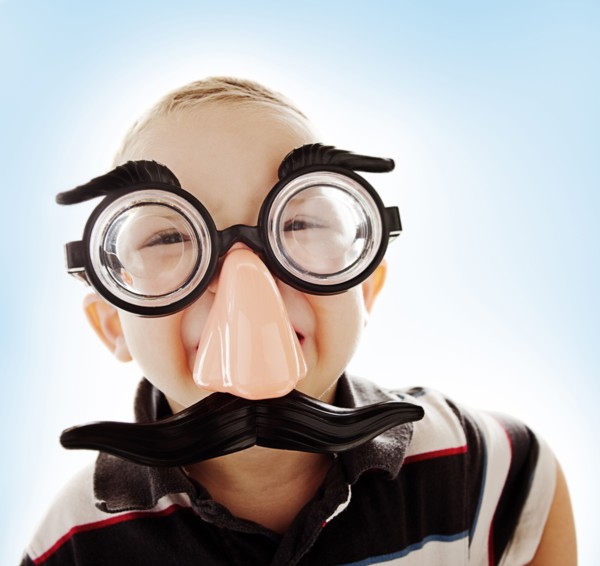 Caucasian boy in funny mustache mask