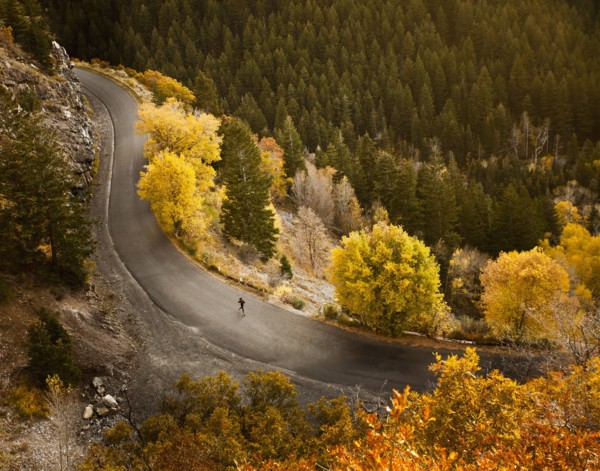 Caucasian woman running along autumn road