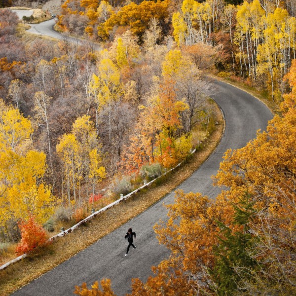 Caucasian woman running along autumn road