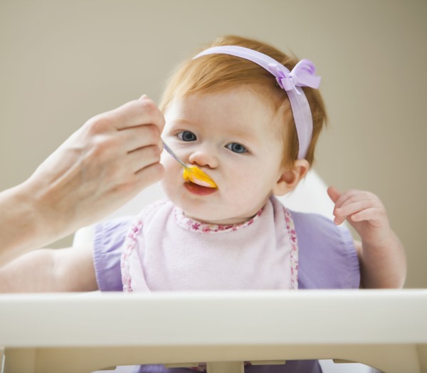 Caucasian mother feeding baby girl