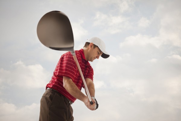Caucasian golfer swinging golf club