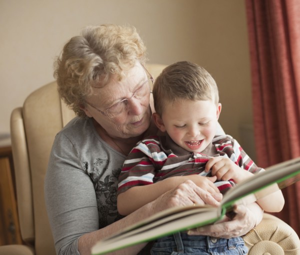 Caucasian grandmother reading book to grandson