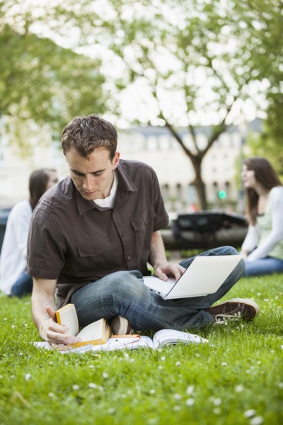 Caucasian man studying in grass