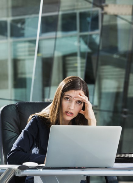 Stressed Caucasian businesswoman at laptop