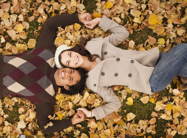 Couple laying in autumn leaves