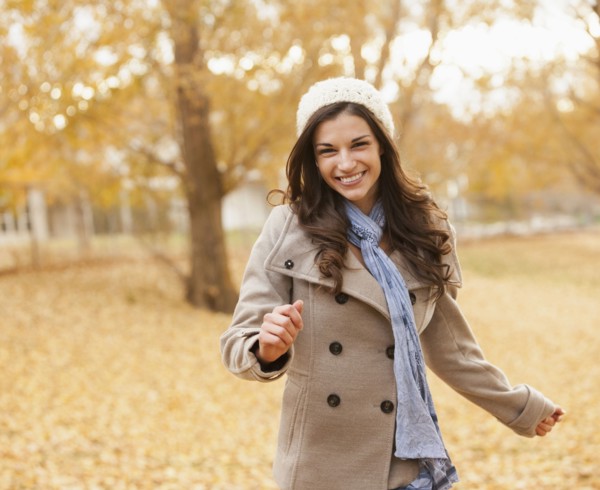 Caucasian woman walking in autumn leaves