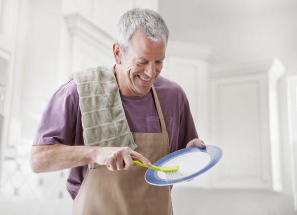 Caucasian man washing dishes in kitchen
