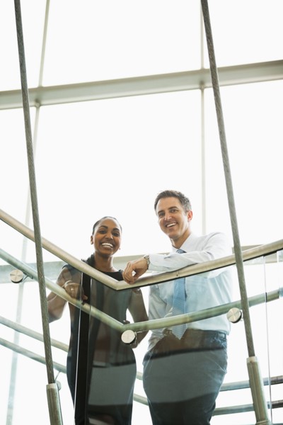 Business people smiling on office staircase
