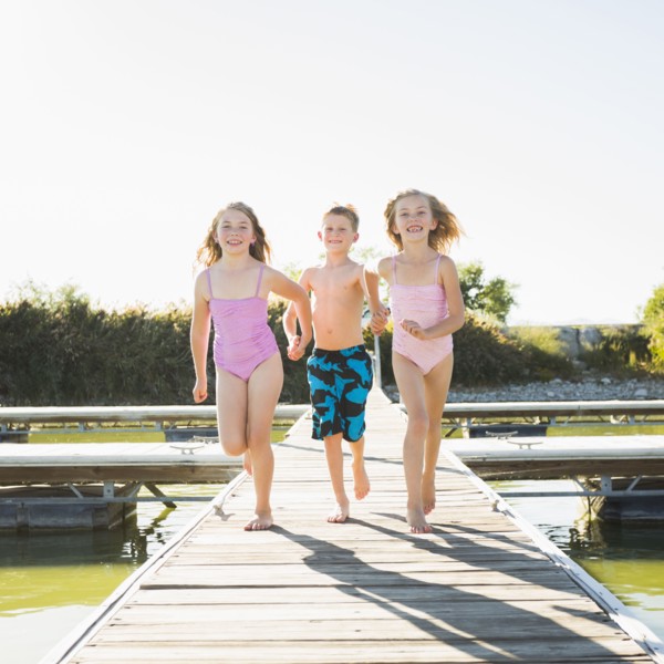Caucasian children running on dock