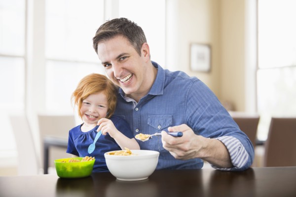 Caucasian father and daughter eating breakfast together