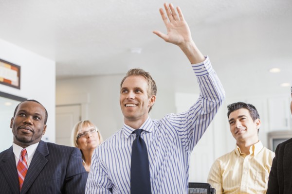 Businessman raising his hand in office