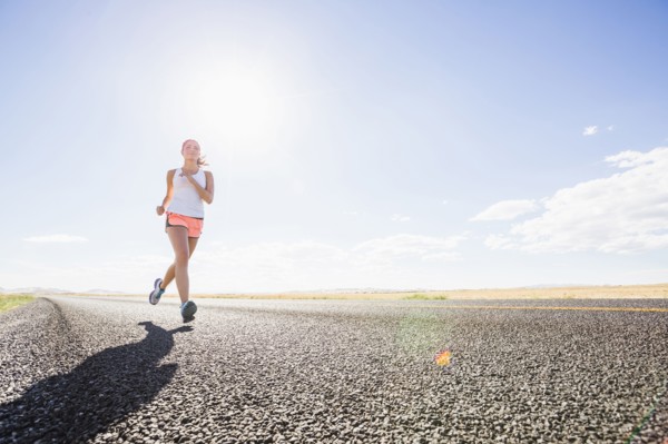 Caucasian woman running on remote road