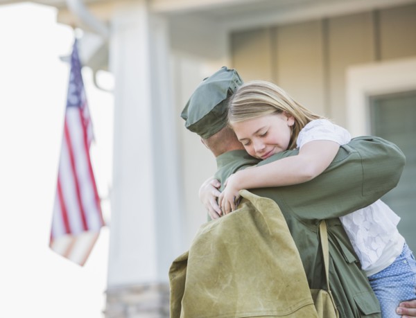 Returning Caucasian soldier hugging daughter