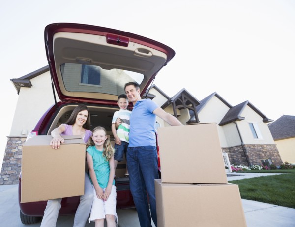 Caucasian family unpacking cardboard boxes from car