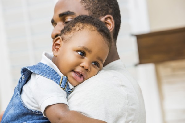 Close up of Black father holding baby son