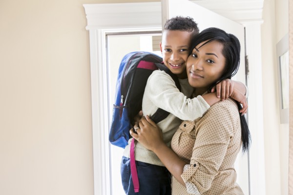 Mother and son hugging at door