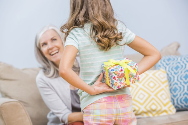 Caucasian girl hiding gift for grandmother behind back