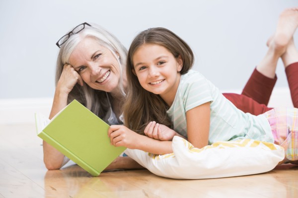 Caucasian grandmother and granddaughter reading book
